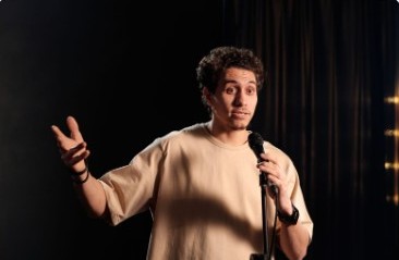 Comedian holding a microphone on a dark stage